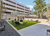Thumbnail 102 of 127 - A patio area with a white building in the background.