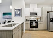 Thumbnail 11 of 140 - Kitchen with white countertops and stainless steel range at Matador Apartments, Austin, 78745