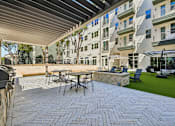 Thumbnail 105 of 127 - A patio with a table and chairs is surrounded by a building.