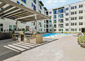 Thumbnail 119 of 127 - A modern building with a pool and a covered walkway.
