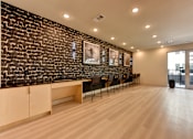 Thumbnail 10 of 46 - A room with a black brick wall and wooden flooring.