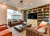 Thumbnail 11 of 46 - A living room with a brown couch, a coffee table, and a bookshelf.