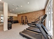 Thumbnail 13 of 46 - A gym with treadmills and weights.