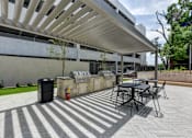 Thumbnail 20 of 46 - A patio with a table and chairs under a white awning.