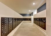 Thumbnail 25 of 46 - A long hallway with black lockers on both sides.