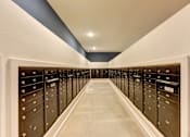 Thumbnail 26 of 46 - A long hallway with a series of black mailboxes on either side.