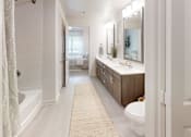 Thumbnail 18 of 21 - A bathroom with a white tub, sink, and toilet.