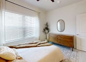 Thumbnail 20 of 21 - A bedroom with a bed, dresser, and window with blinds.