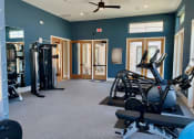 Thumbnail 37 of 52 - a gym with exercise equipment and a ceiling fan at Delco Flats, Austin, 78717