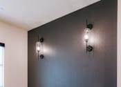 Thumbnail 37 of 46 - A black desk with two chairs and two wall lamps.