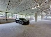 Thumbnail 52 of 140 - Covered parking garage with concrete columns and windows at Matador Apartments, Austin, Texas