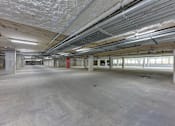 Thumbnail 99 of 140 - Underground parking garage with concrete columns at Matador Apartments, Texas