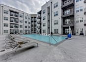 Thumbnail 54 of 140 - Courtyard swimming pool with lounge chairs and balconies at Matador Apartments, Austin, 78745