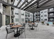 Thumbnail 61 of 140 - Outdoor courtyard patio with dining tables and pool at Matador Apartments, Austin, 78745