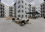 Thumbnail 67 of 140 - Courtyard fire pit seating area with pergola at Matador Apartments, Austin, 78745