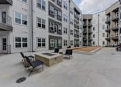Thumbnail 68 of 140 - Outdoor courtyard with fire pit seating area at Matador Apartments, Austin, Texas