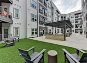 Thumbnail 73 of 140 - Courtyard with artificial turf and modern seating areas at Matador Apartments, Austin, TX