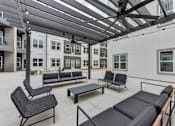 Thumbnail 75 of 140 - Covered outdoor lounge with modern furniture and seating at Matador Apartments, Austin