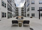 Thumbnail 78 of 140 - Central courtyard with seating and fire feature at Matador Apartments, Austin, TX 78745