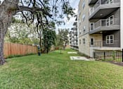 Thumbnail 84 of 140 - Green lawn area with mature oak trees and balconies at Matador Apartments, Austin, 78745