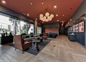Thumbnail 34 of 140 - Modern lobby with lounge seating and statement chandelier at Matador Apartments, Austin, TX