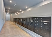 Thumbnail 43 of 140 - Mail room with wall of secure parcel lockers at Matador Apartments, Austin, Texas