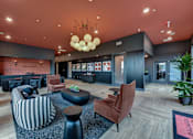 Thumbnail 31 of 140 - Community lounge with games and velvet armchairs at Matador Apartments, Texas