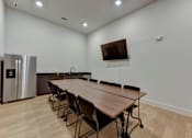 Thumbnail 48 of 140 - Conference room with dining table and wall mounted tv at Matador Apartments, Austin, TX