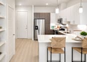 Thumbnail 36 of 46 - A kitchen with a white counter and a refrigerator.