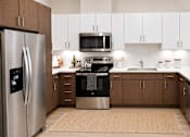 Thumbnail 37 of 46 - A modern kitchen with a refrigerator, oven, microwave, and sink.