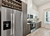Thumbnail 6 of 44 - a kitchen with stainless steel appliances and two tone cabinets with wine racks at Bridge at Windsor Park