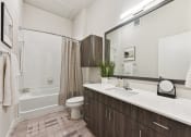 Thumbnail 10 of 44 - A luxury bathroom with large mirror and quartz counters at Bridge at Windsor Park