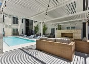 Thumbnail 29 of 44 - Seating and fireplace by the pool at Windsor Park