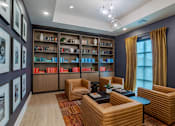 Thumbnail 4 of 55 - A room with a bookshelf, a table, and chairs.