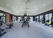 Thumbnail 10 of 55 - A spacious gym with a variety of equipment and a large mirror on the wall.
