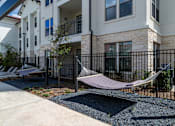 Thumbnail 15 of 55 - A hammock is strung between two balconies of a multi-story apartment building.