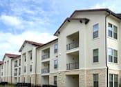 Thumbnail 45 of 46 - A row of apartment buildings with balconies and doors.