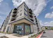 Thumbnail 45 of 51 - A modern building with a glass entrance and a stone facade.