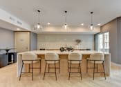 Thumbnail 13 of 51 - A modern kitchen with a bar area and four stools.