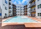 Thumbnail 1 of 51 - A swimming pool in the middle of a courtyard surrounded by buildings.