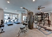 Thumbnail 21 of 51 - A spacious home gym with a variety of equipment including a treadmill, elliptical machines, and weight machines.