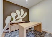 Thumbnail 28 of 51 - A room with a brown wall and a wooden desk with a plant on it.