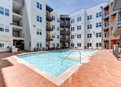 Thumbnail 2 of 51 - A large swimming pool in the middle of a courtyard surrounded by apartment buildings.