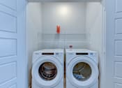 Thumbnail 33 of 51 - Two white front load washing machines in a laundry room.