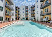 Thumbnail 3 of 51 - A swimming pool in front of apartment buildings.