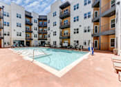 Thumbnail 4 of 51 - A large swimming pool in the middle of a courtyard surrounded by apartment buildings.