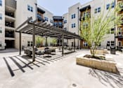 Thumbnail 5 of 51 - A courtyard with a tree and a bench.
