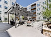 Thumbnail 6 of 51 - A patio with a table and chairs under a pergola.