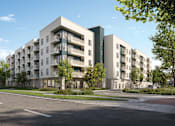 Thumbnail 39 of 46 - A modern apartment building with a parking lot in front.
