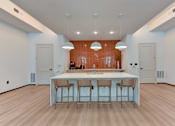 Thumbnail 11 of 51 - A kitchen with a bar area and four stools.